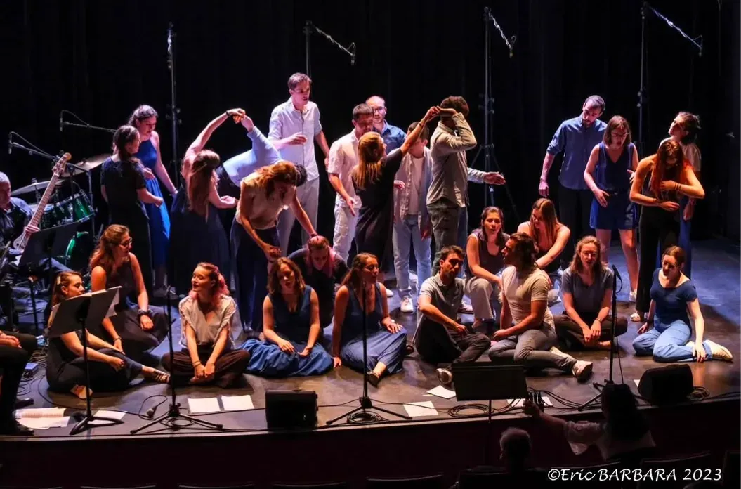 Choir performing, singers in evening dress on stage.
